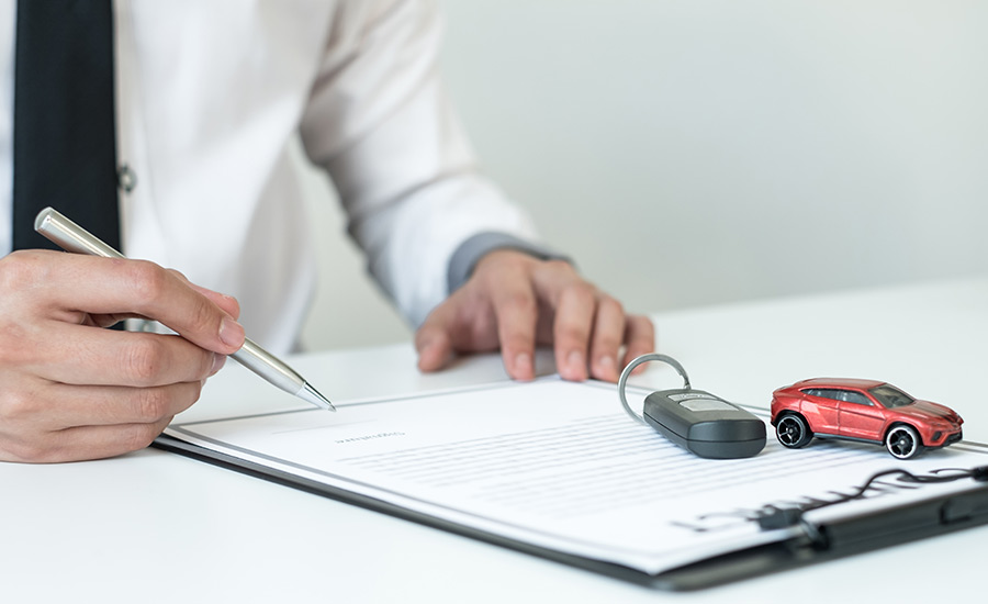 A man signing an auto insurance policy